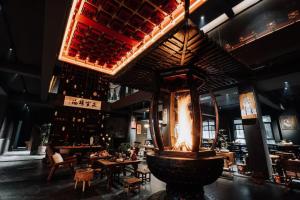 a restaurant with a large fountain in the middle of a room at Wuzhen FortuneCourt Hotel in Jiaxing