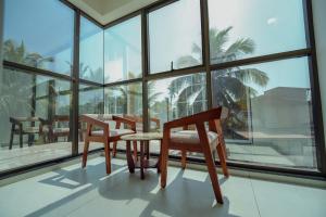 a room with chairs and a table and windows at Green View Suites in Kalyānpur