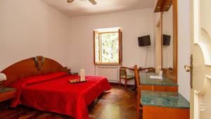 a bedroom with a red bed with a red blanket at Affittacamere Villa Gigli in Sirolo