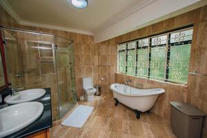 a bathroom with two sinks and a tub and a shower at Karen Crown 5BR Villa in Nairobi +22 photos