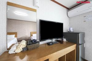 a room with a flat screen tv on a desk at Jeju Island Love in Jeju