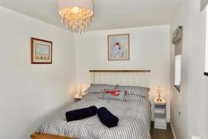a bedroom with a bed and a chandelier at Little Barn, Greendale Farm in Barnstaple