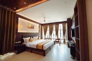 a hotel room with a bed and a dining room at Green View Suites in Kalyānpur