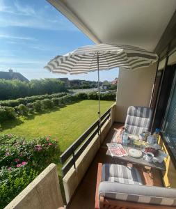 a patio with an umbrella and a table and chairs at Deichblick in List