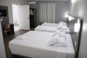 two beds in a hotel room with white towels on them at DE STEFANI HOTEL in Portão +37 photos