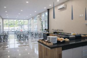 a restaurant with a counter and tables and chairs at DE STEFANI HOTEL in Portão