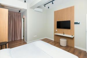a bedroom with a bed and a tv on a wall at Hotel Relax City Center in Tirana