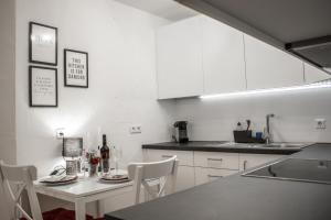 a kitchen with white cabinets and a white table and chairs at Ferienwohnung Bela in Wangen im Allgäu