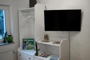 a flat screen tv on a wall with a shelf at Ferienwohnung Bela in Wangen im Allgäu