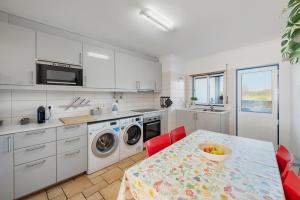 a kitchen with a table with a bowl of fruit on it at Casa de Baixo in Odeceixe