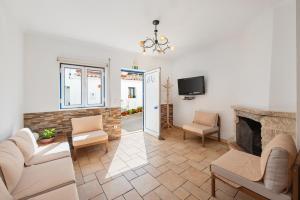 a living room with a fireplace and a tv at Casa de Baixo in Odeceixe