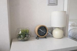a table with a clock and a lamp and a vase at Acqua & Luce in Meina