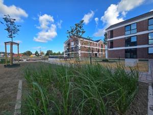 a view of a building with tall grass at Ferienwohnung NordTroll in Norden