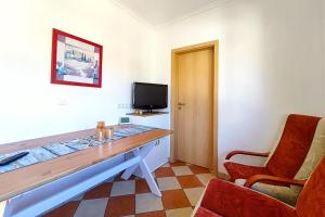 a room with a desk with a tv and a chair at Ferienwohnung Sonnenschein in Loddin