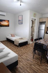 a room with two beds and a table and a refrigerator at Farma Giannis in Sarti