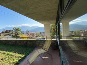 a balcony with two chairs and a view of the mountains at Villa Cavalli in Verscio