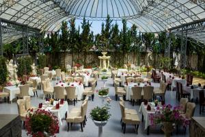 a banquet hall with white tables and chairs and flowers at Mallorie Hotel Dalat in Xuan An