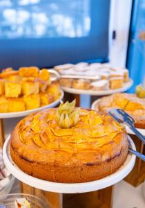 a table topped with plates of pies and other desserts at Sea & Sand Hotel in Vlorë +268 photos