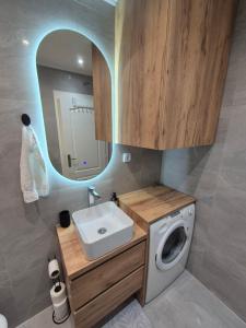 a bathroom with a sink and a washing machine at Apartman Ana Bijeljina in Bijeljina