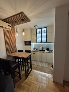 a kitchen with a table and a dining room at Apartman Ana Bijeljina in Bijeljina