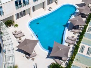 an overhead view of a swimming pool with chairs and umbrellas at Apartment Garden Palace D414 in Umag