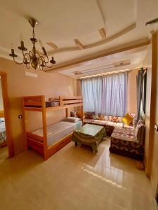 a bedroom with a bunk bed and a couch at Genova surf house in Imsouane