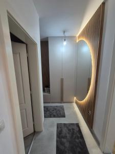 a hallway with a round mirror and a door at Apartman Ana Bijeljina in Bijeljina
