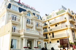 a row of white buildings with balconies at Mallorie Hotel Dalat in Xuan An