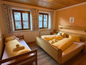 two beds in a room with two windows at Rössingerhof in Ramsau am Dachstein