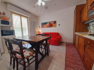 a kitchen with a table and chairs and a red couch at B&B L'Incancellata in Corinaldo