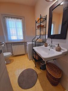 a bathroom with a sink and a mirror and a toilet at B&B L'Incancellata in Corinaldo