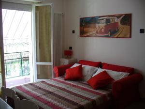 a bed with red pillows in a room with a window at B&B L'Incancellata in Corinaldo