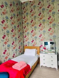 ein Schlafzimmer mit einem Bett und einer Kommode mit Spiegel in der Unterkunft Eliza House in Edinburgh