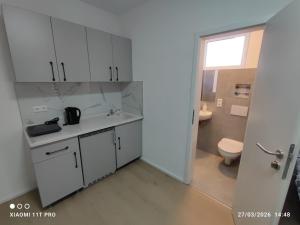 a white kitchen with a toilet and a sink at City Apartments Göppingen in Göppingen +68 photos