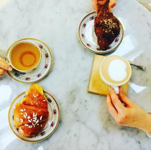 a table with plates of food and cups of coffee at Zahira suite&spa in Palermo