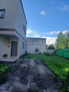 an empty yard next to a white building at Duplex Los Araujos in Yerba Buena