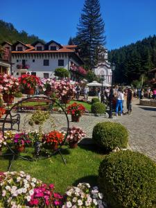 a group of flowers in a park with a building at Apartman Aurora in Golubac