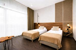 a hotel room with two beds and a table at Lake Hill Studio 35- strefa wellness w cenie in Sosnówka +14 photos