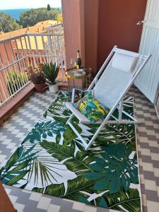 a chair on a balcony with a tropical floor at Marina Elite Capo D'Arco in Capo D'Arco