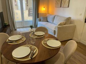 a living room with a table with plates and wine glasses at La Parenthèse de Foch in Le Puy-en-Velay