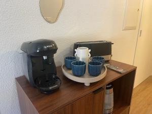a coffee maker and cups on top of a counter at La Parenthèse de Foch in Le Puy-en-Velay