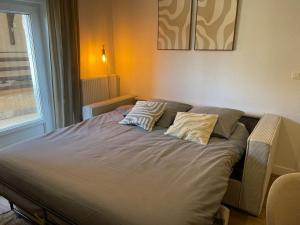 a bed in a room with two pillows on it at La Parenthèse de Foch in Le Puy-en-Velay