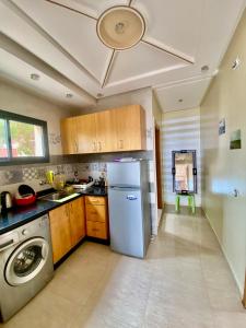 a kitchen with a refrigerator and a washing machine at Genova surf house in Imsouane