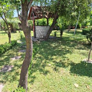 a tree in a yard with a gazebo at Dusica in Vrnjačka Banja