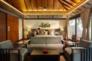 a bedroom with a bed and a living room at Tilar Siro Andamans - A CGH Earth Experience in Havelock Island