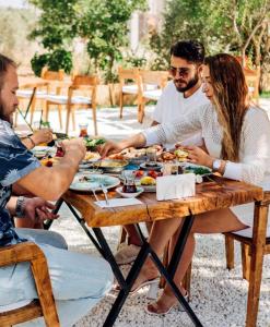 a group of people sitting around a table eating food at Riserva Urla in Urla