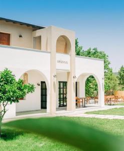 a white house with arches and a lawn at Riserva Urla in Urla +20 photos