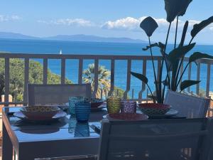 a table with bowls and plates on a balcony with the ocean at Marina Elite Capo D'Arco in Capo D'Arco +41 photos