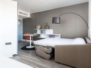 a bedroom with a bed and a table and a chair at Novotel Suites Perpignan Centre - Grandes Suites & Confort Centre-Ville in Perpignan +118 photos