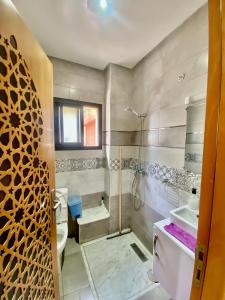a bathroom with a shower and a toilet and a sink at Genova surf house in Imsouane +46 photos